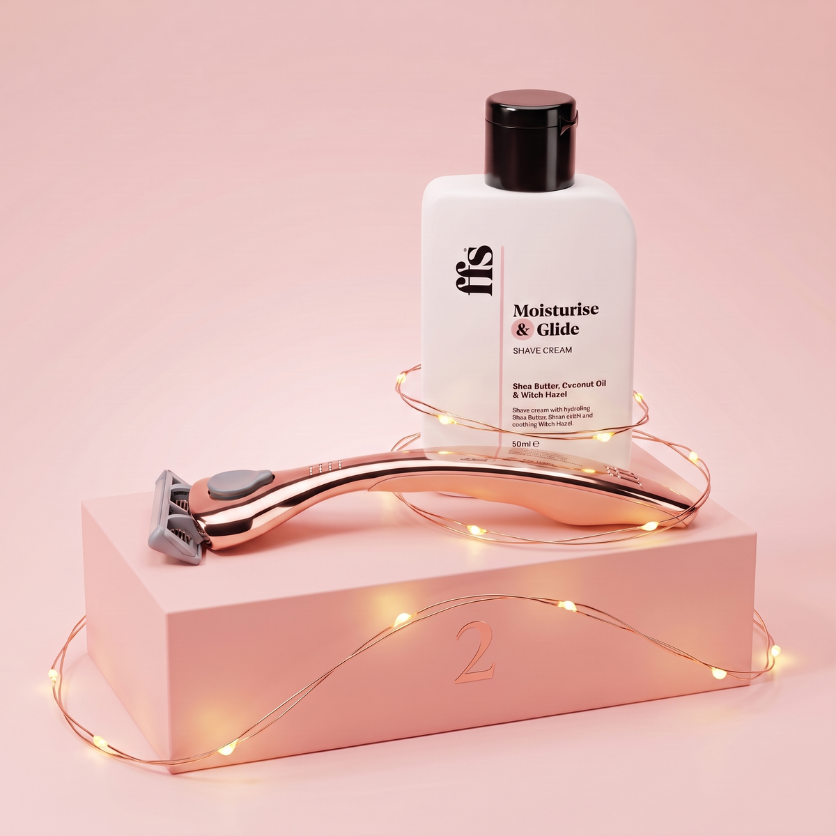FFS Moisturise & Glide shave cream and rose gold razor with fairy lights on a pink podium