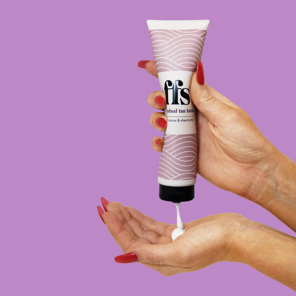 Female hand squeezing tan lotion tube to get lotion on hand